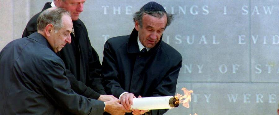 Former U.S. President Bill Clinton (C) lights the eternal flame with Memorial Council Chairman Harvey Meyerhoff (L) and Founding Chairman Elie Wiesel (R) at the United States Holocaust Memorial Museum in Washington, D.C., April 22, 1993. 
