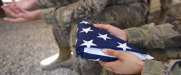 A US soldier holds the national flag ahead of a handover ceremony at Leatherneck Camp in Lashkar Gah in the Afghan province of Helmand on April 29, 2017.