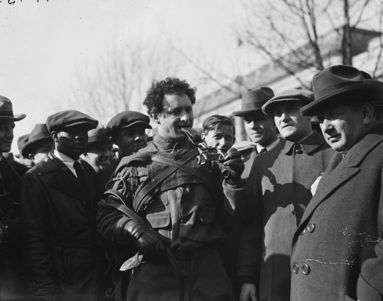 Siegmund ‘Zishe’ Breitbart, surrounded by onlookers, after pulling a person-filled wagon through the streets of Washington, D.C., with his teeth, 1923