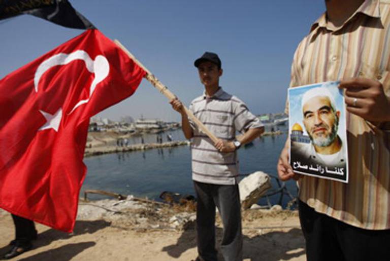 A Palestinian youth waves a Turkish flag while another protester (R) holds a picture of Arab Israeli Islamist leader Sheikh Raed Salah, Gaza City, May 31, 2010.(Said Khatib/AFP/Getty Images)