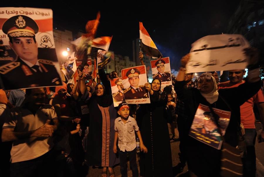 Opponents of deposed Egyptian President Muhammad Morsi hold portraits of Egyptian army chief General Abdel as they demonstrate at a Ittihadiya main street in Cairo, late on July 26, 2013.(Fayez Nureldine/AFP/Getty Images)