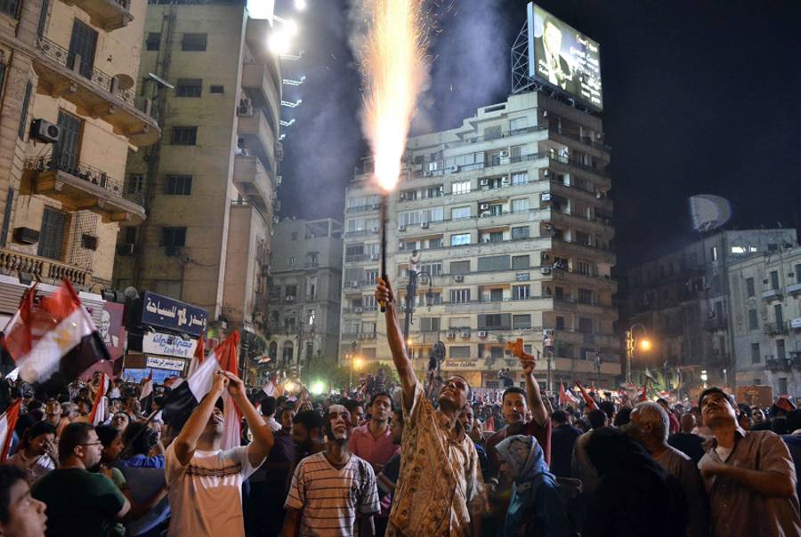 An Egyptian protester lights up a flare as hundreds of thousands of Egyptian demonstrators gather in Cairo's landmark Tahrir Square during a protest calling for the ouster of President Mohamed Morsi on July 1, 2013.(Mohamed El-Shahed/AFP/Getty Images)