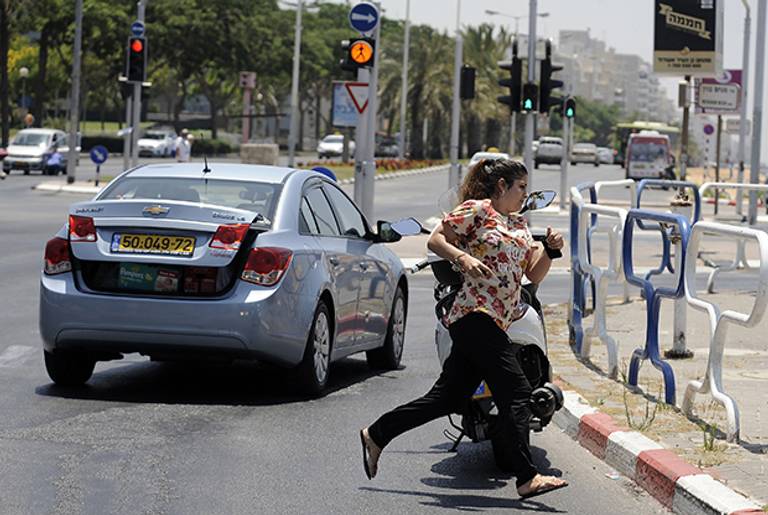 A woman runs to take cover in the Israeli city of Ashdod on July 10, 2014 during a rocket attack by Palestinian militants from the nearby Gaza Strip. (DAVID BUIMOVITCH/AFP/Getty Images)
