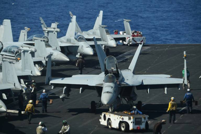Sailors prepare FA-18 Hornet fighter jets for takeoff during a routine training aboard the U.S. aircraft carrier Theodore Roosevelt in the South China Sea, 2018