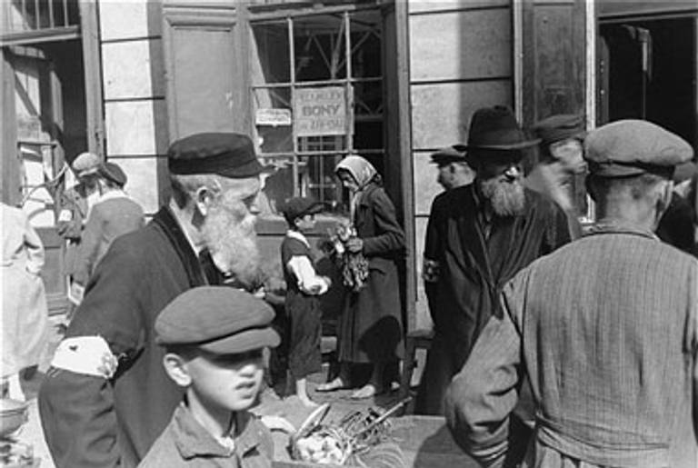 Ghetto residents make purchases from street vendors in the Warsaw Ghetto, 1941.(Photo: Willy Georg, courtesy United States Holocaust Memorial Museum.)