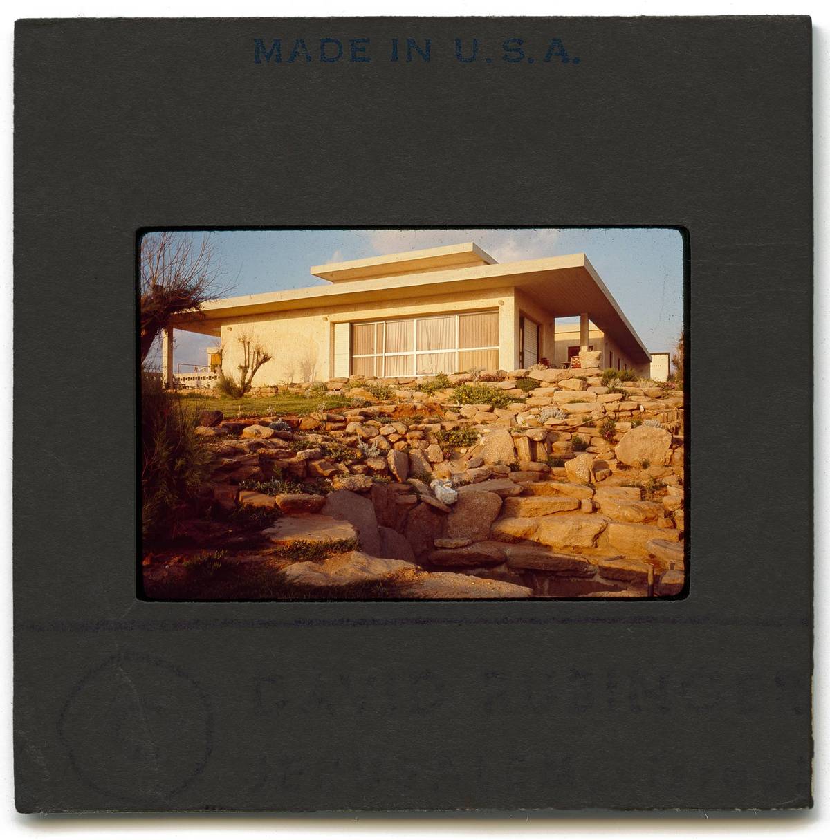 View of the house facing the sea. The pool is in the foreground. The water cascaded down along a ‘natural’ path of stones and ancient marble slabs, columns, and capitals that he’d pilfered from Roman ruins. The pool itself was made from sandstone rocks he’d had hauled from the beach. But because they were porous, the pool never held its water.