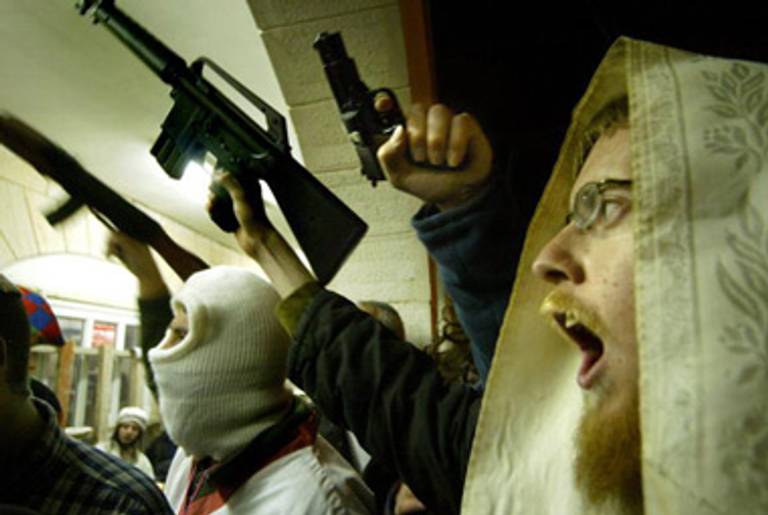 Jewish residents of Hebron brandish toy guns at a reading of the megillah, 2005.(Gali Tibbon/AFP/Getty Images)