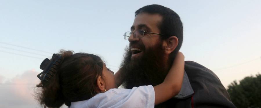 Khader Adnan, a Palestinian prisoner who staged a 56-day hunger strike while being detained for a year without charge by Israeli authorities, hugs a relative as he arrives in the West Bank village of Arraba after his release, July 12, 2015. 
