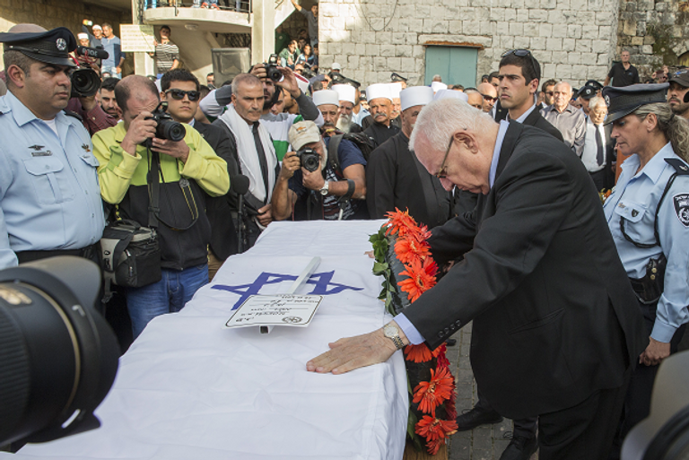 Israeli President Reuven Rivlin (R) pays his respects on the coffin of Israeli police officer Zidan Sayif, 30, a member of Israel's Druze minority, during his funeral in his northern home village of Yanuh-Jat, on November 19, 2014. (Jack Guez/AFP/Getty Images)