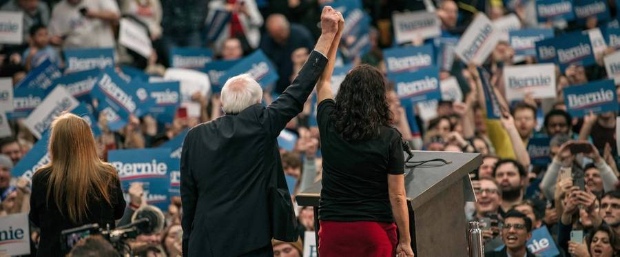 Rep. Rashida Tlaib, D-Michigan, and presidential candidate Sen. Bernie Sanders, I-Vermont, hold hands on stage during a rally at Cass Technical High School on Oct. 27, 2019, in Detroit