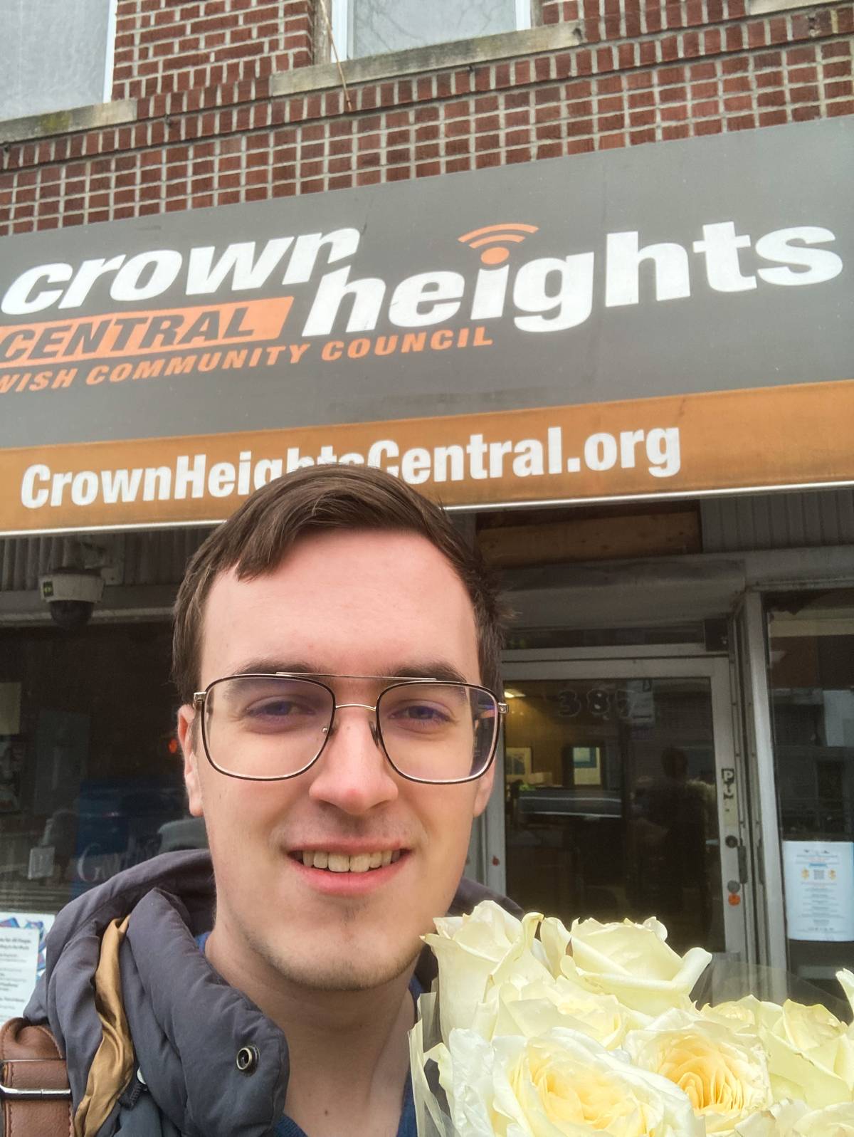 PAL member Josiah in Crown Heights brings flowers to the Crown Heights Jewish Council to express solidarity following an attack on a Hasidic man in January 2023