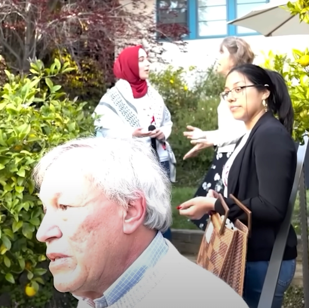 Berkeley Law Dean Erwin Chemerinsky (foreground) pleads with student protestors to leave his home. Behind him, Catherine Fisk (background, right) asks student Malak Afaneh (back, left) to leave.