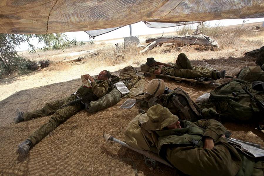 Israeli soldiers rest after returning from combat in the Gaza Strip at the deployment area along the border between Israel and the Hamas-controlled Gaza Strip on July 31, 2014. (Getty Images)