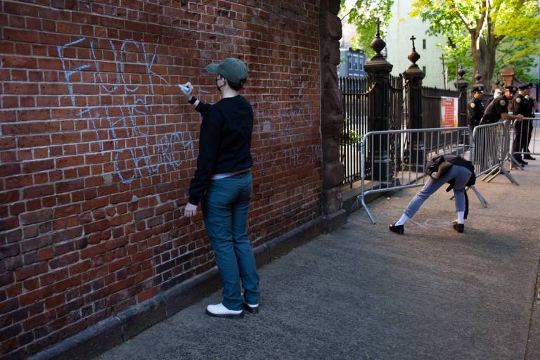 Pro-abortion counterprotesters chalk the wall of St. Patrick's Old Cathedral, the gathering place for a monthly anti-abortion vigil in New York City, May 6, 2023