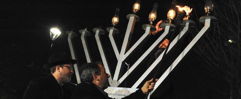 Ron Suskind lights the menorah in Cambridge Common on the evening of Dec. 6, 2018. 