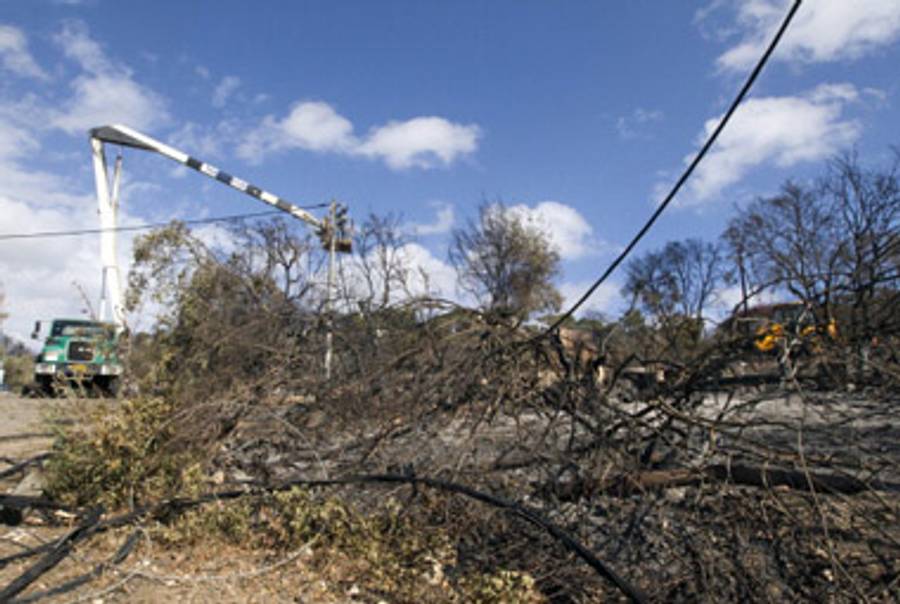 Repairing electricity cables downed in the fire.(Jack Guez/AFP/Getty Images)