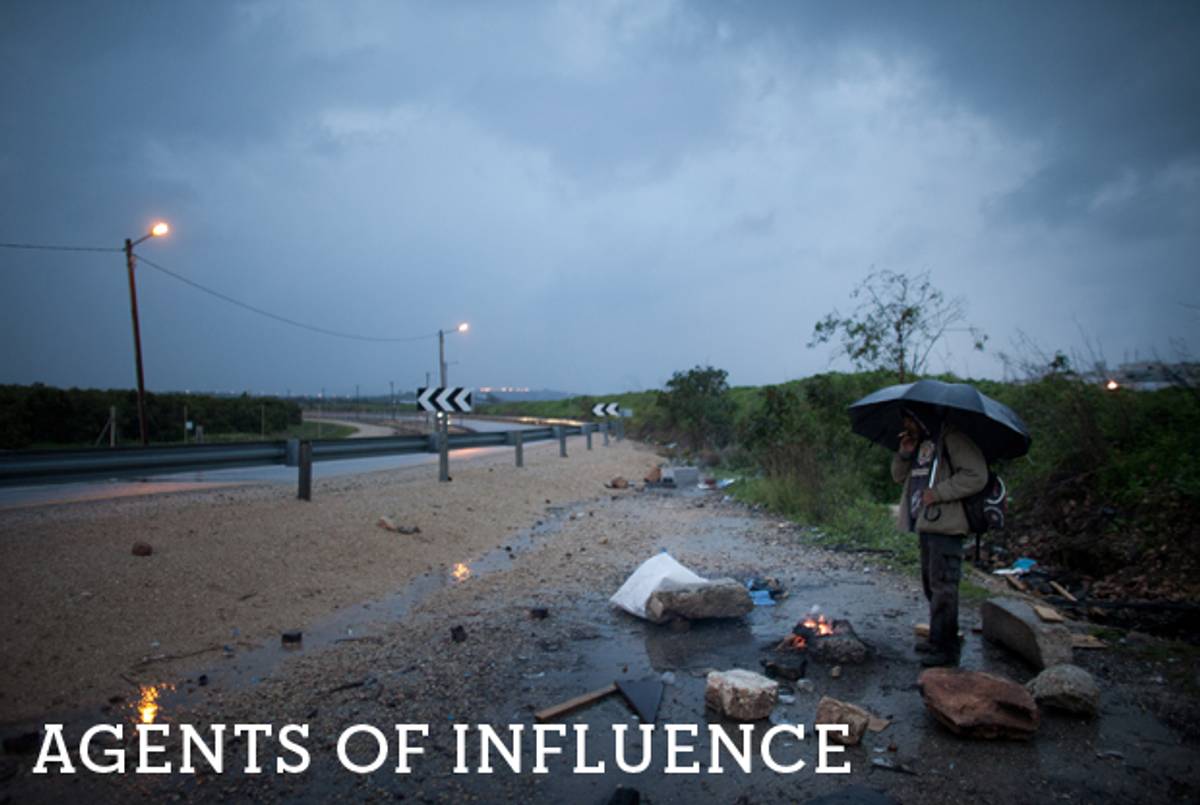 A Palestinian man waits to be collected by his employer near the Israeli army checkpoint at Kibbutz Eyal, after crossing from the West Bank town of Qalqilya on Feb. 19, 2012.(Uriel Sinai/Getty Images)