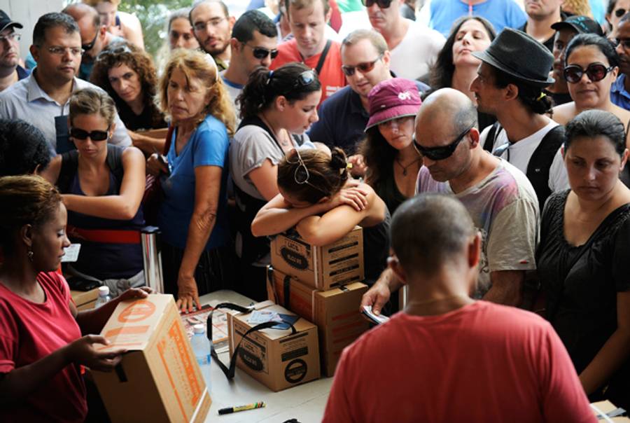 Israelis queue up as they wait to collect their gas masks at a distribution center in Tel Aviv on August 28, 2013. (DAVID BUIMOVITCH/AFP/Getty Images)