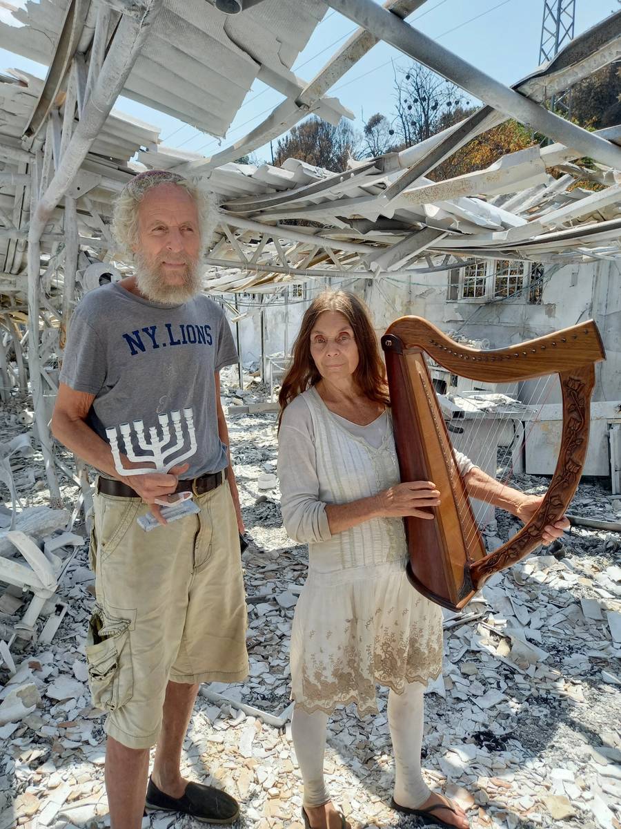 Micah and Shoshanna Harrari, the owners of King David Harps, stand in their destroyed workshop
