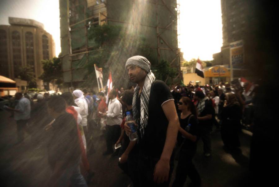 Egyptian protesters, seen through a flag, march toward Cairo's landmark Tahrir square during a demonstration against President Mohammed Morsi on May 17, 2013.(Gianluigi Guercia/AFP/Getty Images)