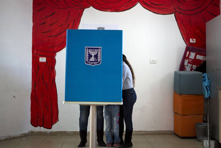 An Israeli woman and her children at a voting booth at a polling station in East Jerusalem on January 22, 2013. (Menahem Kahana/AFP/Getty Images)