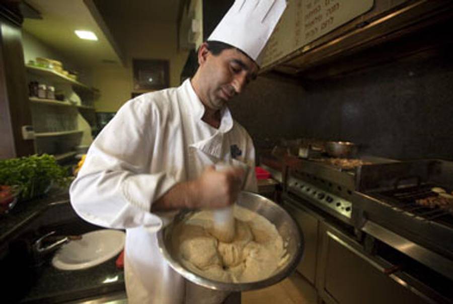 One of the chefs mashes some chickpeas, January 4th.(Menahem Kahana/AFP/Getty Images)