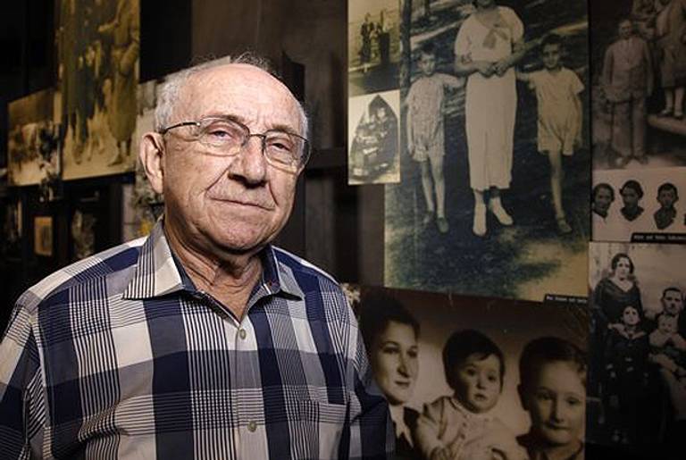 Max Glauben stands in front of photographs taken of him and his mother and brother in Poland at the Dallas Holocaust Museum/Center for Education on Feb. 20, 2014. (David Woo/AP)
