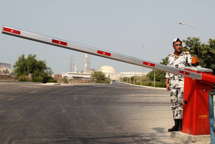 An Iranian soldier stands guard at the entrance to the Bushehr nuclear power plant in southern Iran, 1200 kms south of Tehran, on Aug. 20, 2010.(Atta Kenare/AFP/Getty Images)