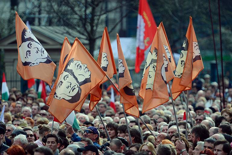 Anti-government demonstrators lift their orange flags with portraits of Russian President Vladimir Putin and Hungarian Prime Minister Viktor Orban in front of the National Museum of Budapest on March 15, 2014. (Attila Kisbendek/AFP/Getty Images)