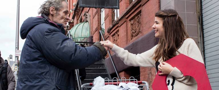 Adina Lichtman, Founder of Knock Knock Give a Sock, interacts with a homeless man in New York City. 