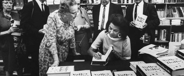 Jacqueline Susann autographing copies of 'Valley of the Dolls' for customers at an LA bookstore.