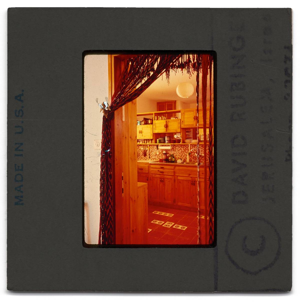 Although neither of my parents did much cooking, the wood cabinetry and deep red floor tiles made this the warmest room in the house. The repurposed Bedouin camel belts made for an effective screen between the kitchen and dining room.