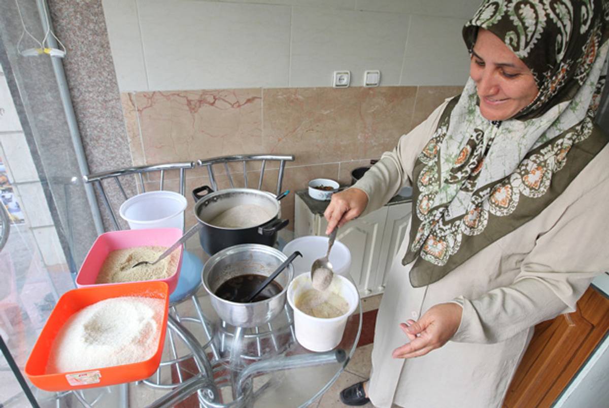 An Iranian woman prepares a cracked wheat and chicken dish.(Atta Kenare/AFP/Getty Images)