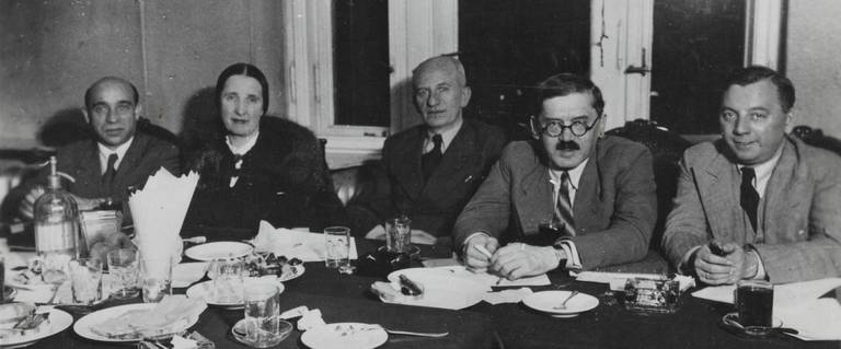 Press conference in JDC office in Warsaw. Left to right: L. Mrs Kahn, Alexander Kahn, I. Giterman. Warsaw, Poland 1937. Giterman is in the glasses.