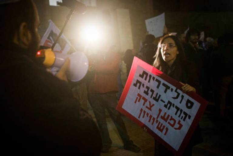 An Israeli activist protesting Shmuel Eliyahu’s edict holds a sign reading “Jewish and Arab solidarity for justice and equality” during a demonstration in Jerusalem last week.(Oren Ziv/ActiveStills)