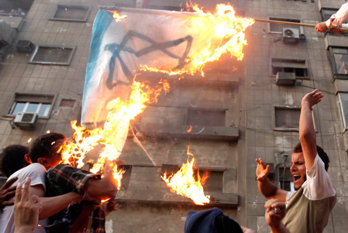 Protesters burn an Israeli flag during a protest in front of the Israeli Embassy in Cairo.(Mohamed Abd El Ghany/Reuters)