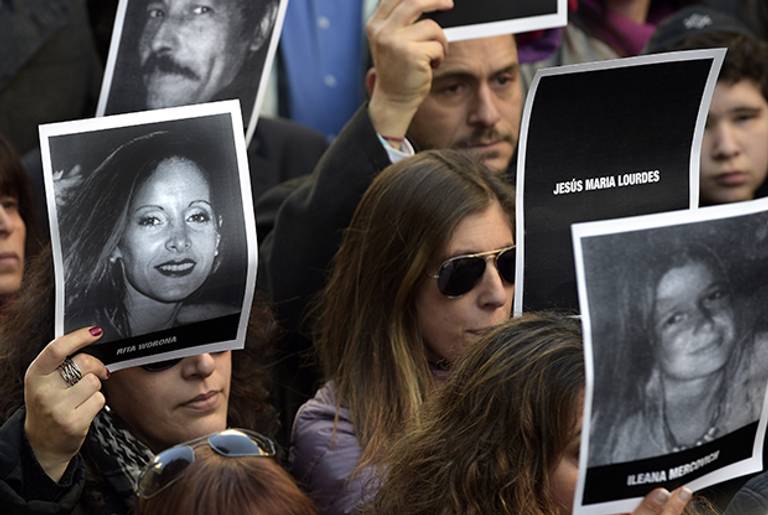 Relatives hold portrait of victims of the terrorist bombing of the AMIA Jewish community center, in which 85 people were killed and 300 were injured, during the commemoration of its 20th anniversary in Buenos Aires on July 18, 2014.(DANIEL GARCIA/AFP/Getty Images)