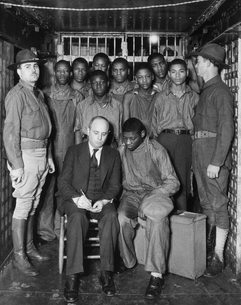 Samuel Leibowitz, seated at left, speaks with Haywood Patterson, one of nine men charged with the rape of two prostitutes on a train. The other defendants are standing behind Leibowitz and Patterson. The subsequent trial would be known as the Scottsboro Boys case.