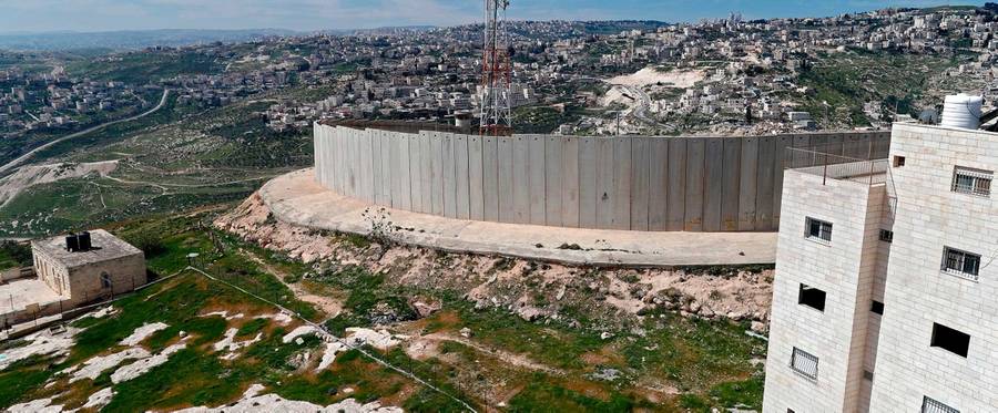 A general view shows Israel's controversial separation barrier between the West Bank city of Abu Dis (foreground) and East Jerusalem (background) on March 13, 2018.