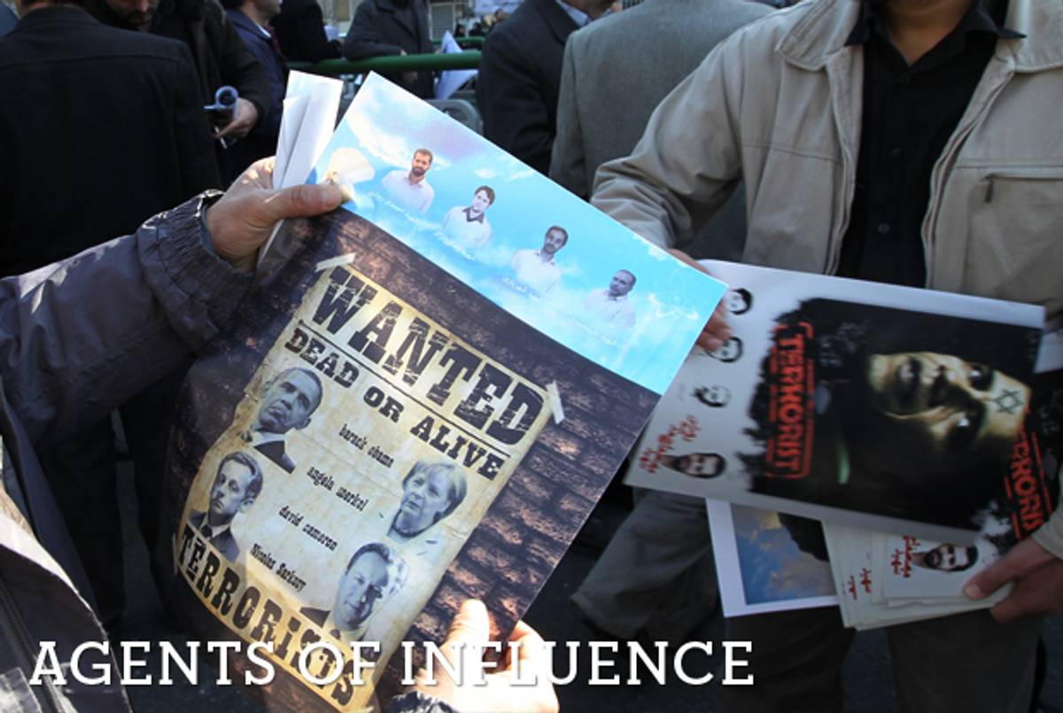 A Iranian man looks at a wanted poster with portraits of U.S. President Barack Obama, German Chancellor Angela Merkel, French President Nicolas Sarkozy, and British Prime Minister David Cameron during the funeral of Iranian nuclear scientist Mostafa Ahmadi-Roshan in Tehran on Jan. 13, 2012, two days after he was killed by a bomb in his car. (Atta Kenare/AFP/Getty Images)