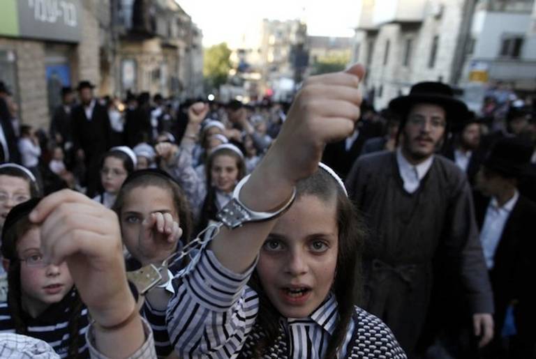 Ultra-Orthodox Jewish children wear handcuffs as they protest against a uniform draft law to replace the Tal Law on July 16, 2012, in Jerusalem.(Getty)