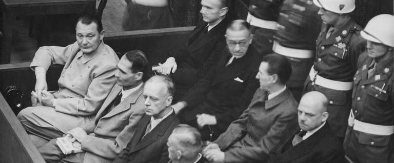 Defendants at the Nuremberg Trials in their dock. In front row, from left to right: Hermann Göring, Rudolf Heß, Joachim von Ribbentrop, Wilhelm Keitel. In second row, from left to right: Karl Dönitz, Erich Raeder, Baldur von Schirach, Fritz Sauckel.