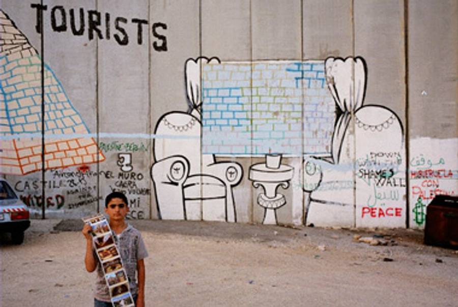A Palestinian boy selling postcards waits by the checkpoint along the partition wall near Bethlehem, West Bank.(Jason Larkin)