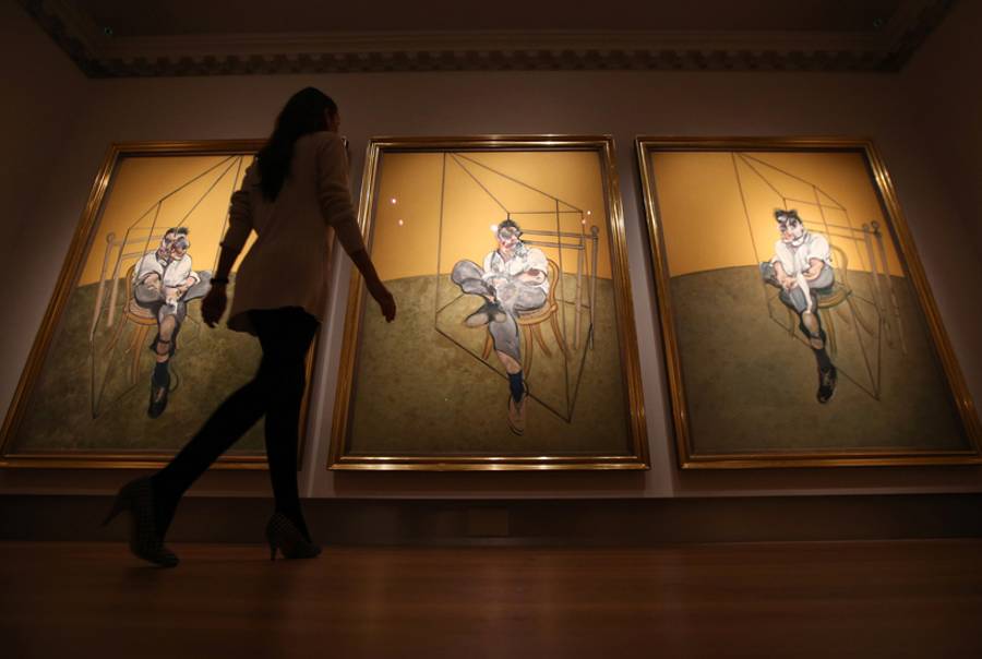 A member of Christie's staff walks toward Francis Bacon's 'Three Studies of Lucian Freud' on October 14, 2013 in London, England.(Peter Macdiarmid/Getty Images)