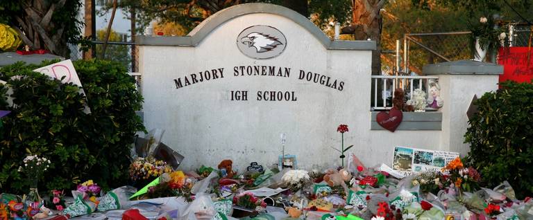Flowers, candles and mementos sit outside one of the makeshift memorials at Marjory Stoneman Douglas High School in Parkland, Florida on February 27, 2018.