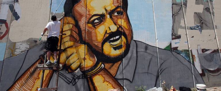 A Palestinian artist finishes a big portrait of jailed Palestinian Fatah leader Marwan Barghuti, on a cement barrier near the Israeli-controlled Qalandia checkpoint, between Jerusalem and Ramallah on May 12, 2010.