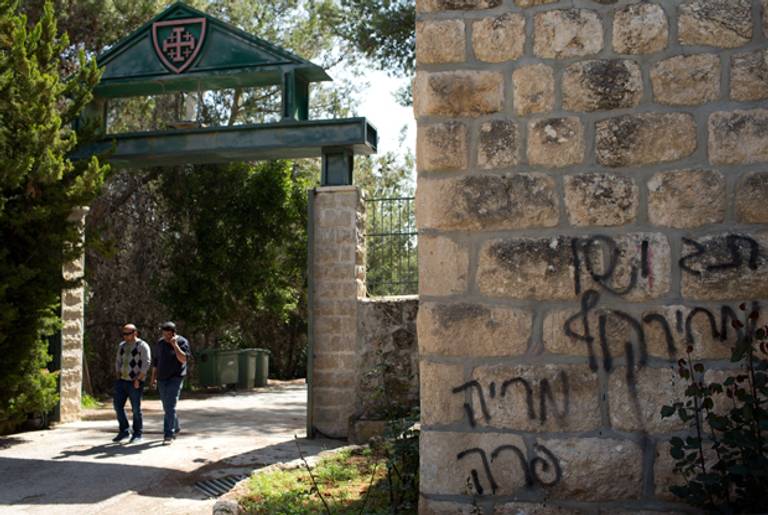 People leave the Deir Rafat Catholic convent whose walls were sprayed with Hebrew graffiti reading 'Jesus monkey' on April 1, 2014 near the Israeli city of Beit Shemesh, west of Jerusalem.(MENAHEM KAHANA/AFP/Getty Images)