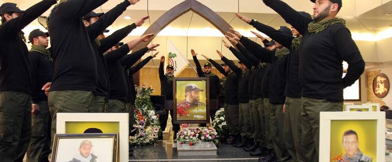 Lebanese Hezbollah militants gesture as they visit the grave of Hezbollah commander Imad Mughnieh, who was killed in a car bombing in the Syrian capital Damascus in 2008, during a ceremony commemorating the 3rd anniversary of his assassination in southern Beirut on February 13, 2011. 