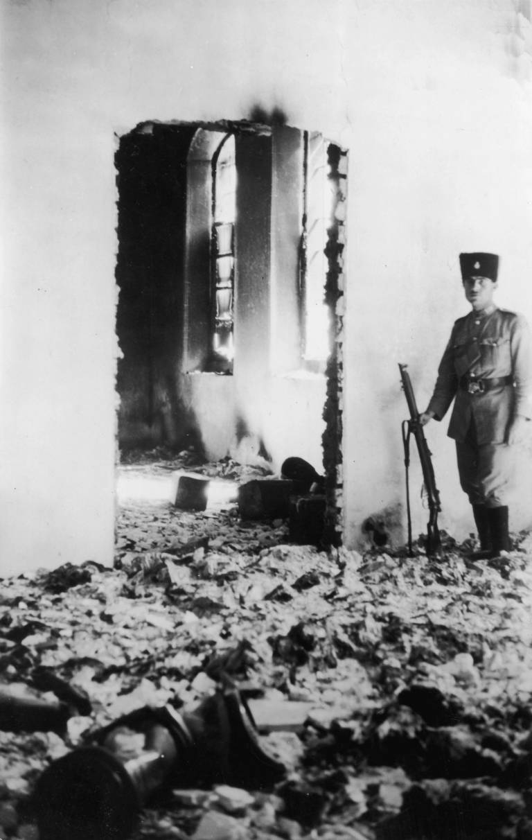 A soldier standing guard in the ruins of a Jewish hospital in Hebron after it was pillaged by Arabs, August 1929. Sixty-seven unarmed Jewish men, women, and children were murdered that day.