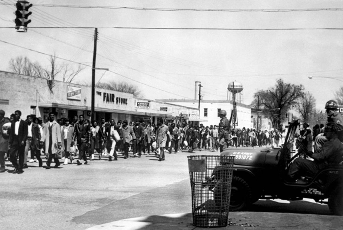 Civil rights demonstrators, led by Dr. Martin Luther King, pass by federal guards as they make their way from Selma to Montgomery on March 23, 1965 in Alabama. (/AFP/Getty Images)